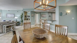Un coin repas avec une table en bois, des chaises et un panier tressé servant de centre de table.