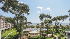 Un complexe hôtelier comprenant plusieurs bâtiments, une piscine et offrant une vue sur la plage.