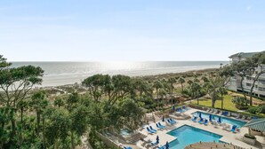 Ein Resort mit Pool, Blick auf den Strand und einem mehrstöckigen Gebäude.