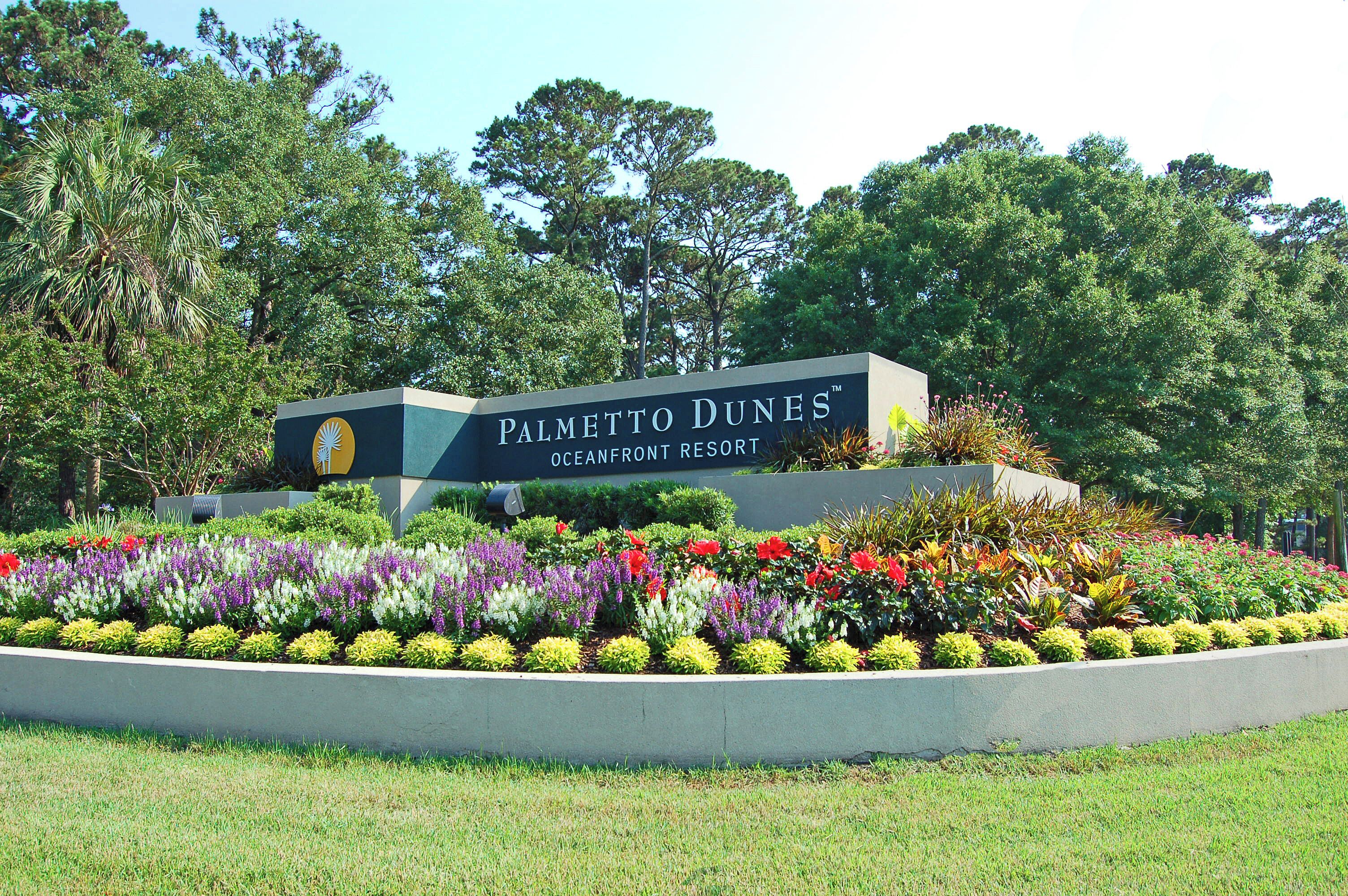 A sign for Palmetto Dunes Oceanfront Resort surrounded by a landscaped garden.