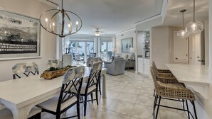 A modern kitchen with a dining area, large windows, and a view of the outdoors. - 2 bedroom villa with oceanfront views from your balcony located in Windsor Ct (Hilton Head Island)