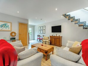 A modern living room with a wooden coffee table, grey sofas, and a red throw blanket. - Ground Floor: 
Open plan living space. (Midgham)