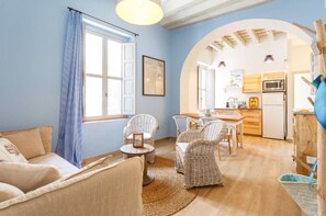 Relax in a warm and inviting living space with a comfortable sofa, wicker chairs, and a cozy rug.