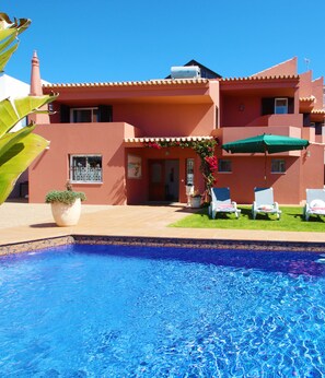 Edifici de dues plantes amb una piscina al davant.