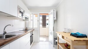 A modern kitchen with white cabinets, a stainless steel sink, and a wooden countertop. - Home2Book Paradise Los Cristianos, Pool & Wifi (Los Cristianos)
