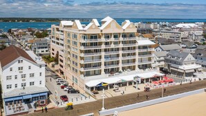 A multi-story hotel with balconies, a beachside location, and a view of the ocean.