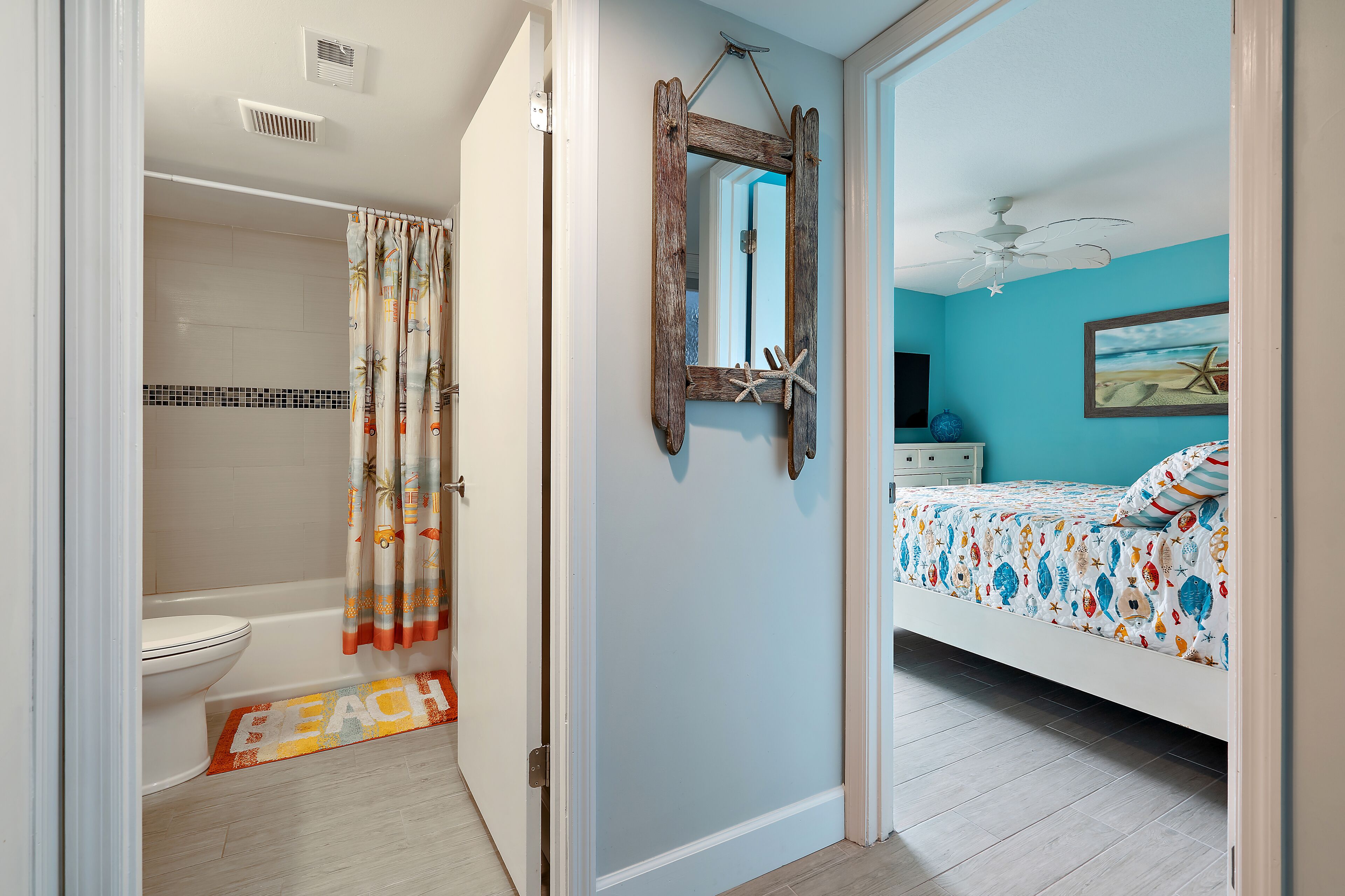 A bathroom with a shower, toilet, and a decorative shower curtain.
