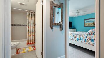 A bathroom with a shower, toilet, and a decorative shower curtain.