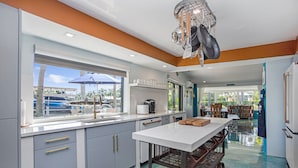 A modern kitchen with a large window, white cabinets, and a central island.