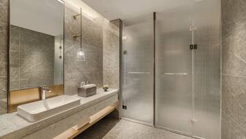 Un bagno moderno con uno specchio grande, due lavandini, cabina doccia e mobile bagno in legno.