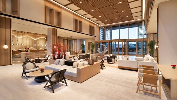 A spacious lobby with a high ceiling, modern furniture, and large windows offering a view of the cityscape. - Crowne Plaza Zunhua Hot Spring Town by IHG (Tangshan)