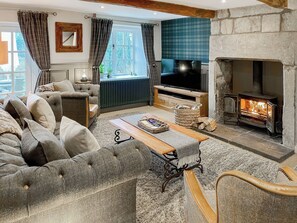 Un salon confortable avec un canapé, une table basse, une cheminée et un téléviseur.