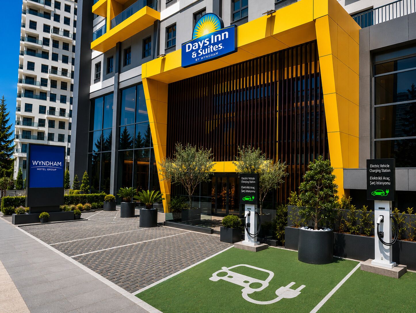 A hotel with a Days Inn & Suites sign, electric vehicle charging stations, and a Wyndham Hotel Group sign.