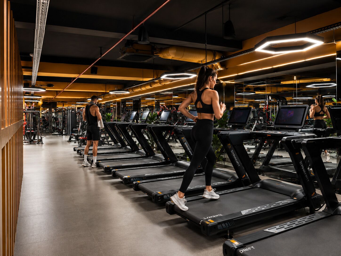 Et fitnesscenter med løbebånd, styrkemaskiner og træningsudstyr.