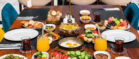 A table set for breakfast with various dishes, a lamp, and a view of the city.
