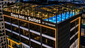 Ein Hotel mit Dachpool, mehreren Etagen und Stadtansicht im Hintergrund.