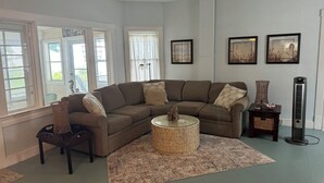 A living room with a sectional sofa, a round coffee table, and a floor lamp.