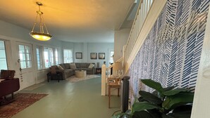 A spacious living room with a sectional sofa, a coffee table, and a staircase leading to an upper level.