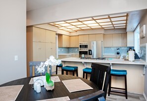 Enjoy meals in the kitchen and dining area, featuring a refrigerator, microwave, and dining table with chairs.
