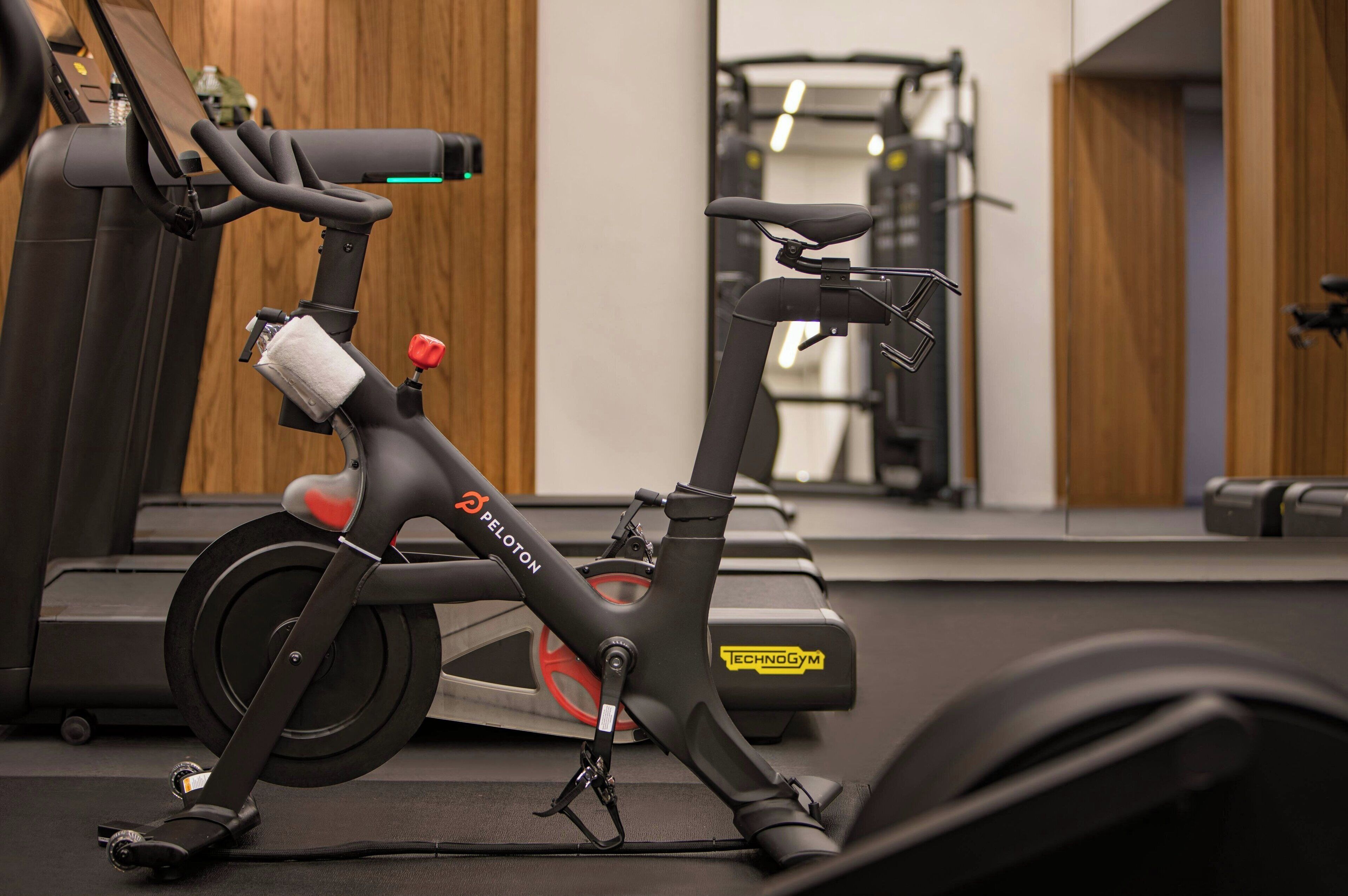 Un vélo d’appartement doté d’un panneau de commande et d’un miroir, installé dans une salle de sport.