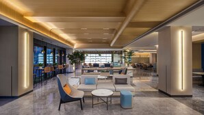 A modern lobby with seating areas, a bar, and a reception desk. - Holiday Inn Express Beijing Yizhuang Center by IHG (Beijing)