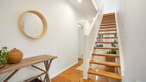 A staircase with wooden steps and a white wall.