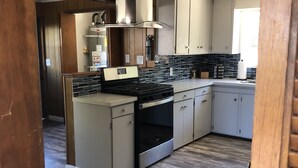 A kitchen with a central island, stainless steel appliances, and wooden cabinetry.