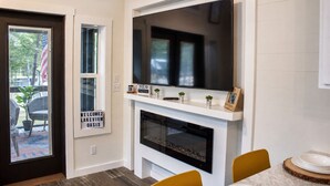 A modern interior with a fireplace, a flat-screen TV mounted above it, and a sign reading 'WELCOME TO LAKEVIEW OASIS.' - Lakeview Oasis at The Retreat at Water's Edge (Tracy City)