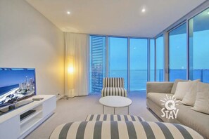 Relax in this stylish living room with a large flat-screen TV, comfortable sofa, and city views.
