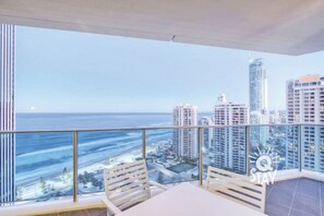 Enjoy breathtaking views of the coastal city from your balcony with a seating area and table.