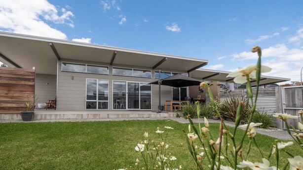 A modern house with a covered patio, large windows, and a well-maintained lawn. - Amaroo 2 - Freycinet Holiday Houses (Coles Bay)