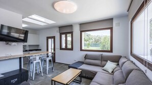A modern living space with a kitchen, dining area, and seating area. - Cortijo Villa Maroma Órgiva by Ruralidays (Granada)