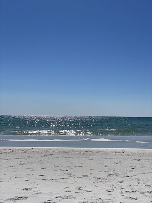 A beach with a clear sky and calm sea.