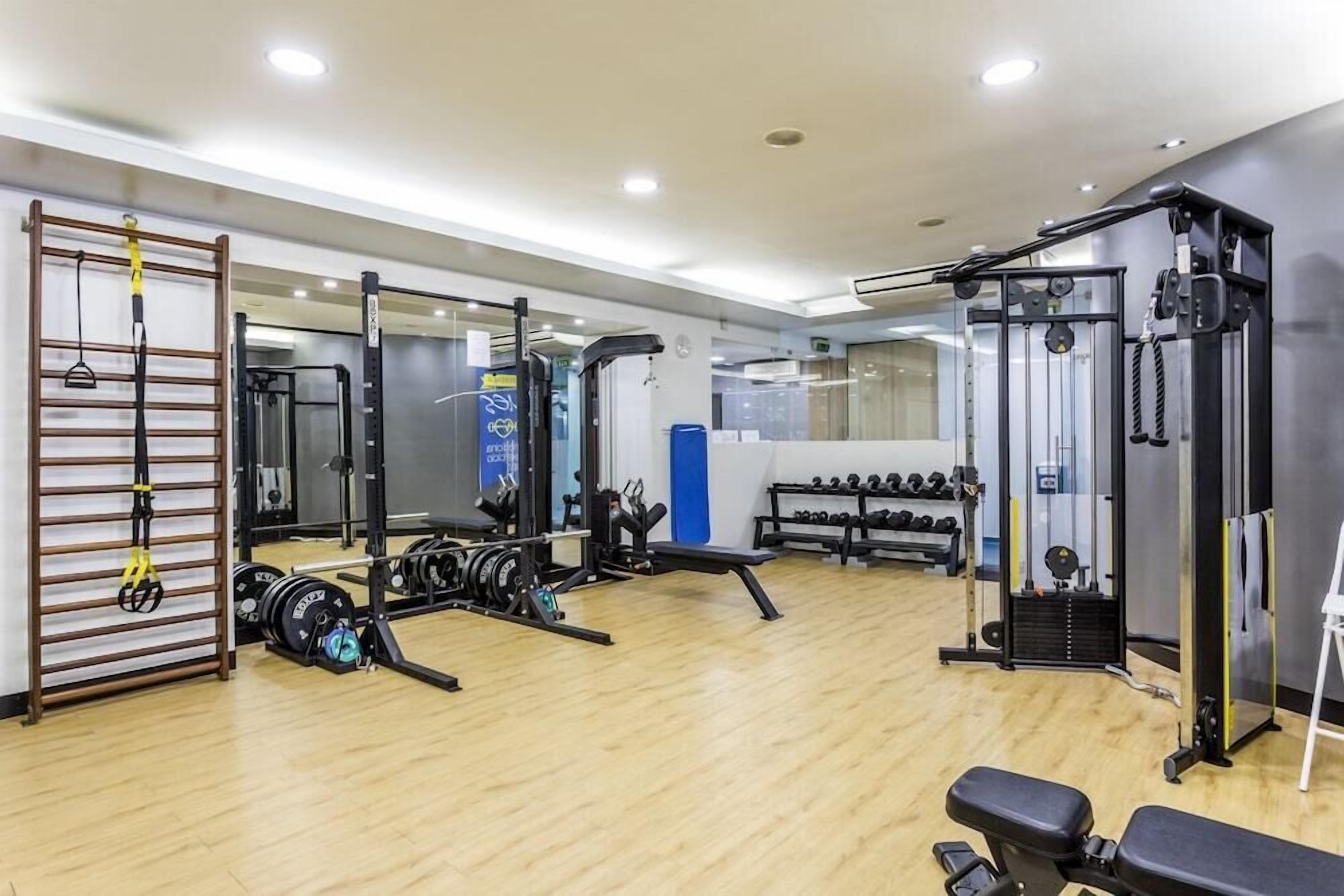 Ein Fitnessraum mit Gewichtstrainern, einer Klimmzugstange und einer Trainingsbank.
