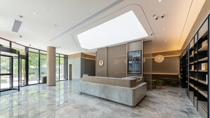 A modern hotel lobby with a reception desk, large windows, and a high ceiling. - Ji Hotel Shanghai Xinzhuang (Shanghai)