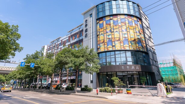 A modern hotel with a curved facade, large windows, and a visible entrance. - Ji Hotel Shanghai Xinzhuang (Shanghai)