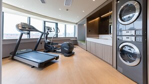A modern gym with treadmills, an elliptical, and a large wall-mounted washer. - Ji Hotel Shanghai Xinzhuang (Shanghai)