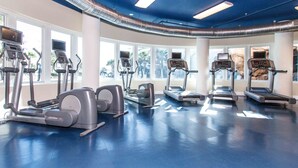 Un gimnasio con cintas de correr, elípticas y máquinas de pesas.