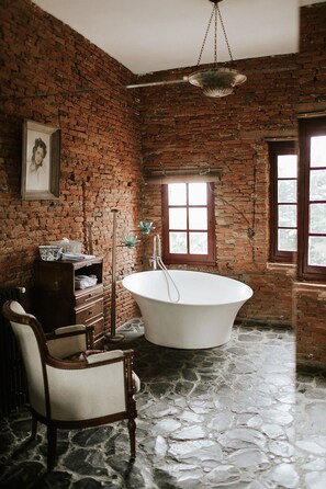 Relax in a serene space with a bathtub and a brick wall adding rustic charm.