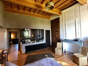 Relax in this stylish room with a large bed, wicker chairs, and a small table.