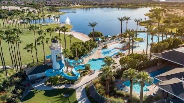 A resort with a large pool, water slides, palm trees, and a lighthouse. - 5 STAR Goodyear Spring Training Hiking Mountain Views Heated Pool Included (Goodyear)