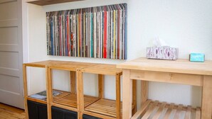 A wooden table with a shelf above it, a wall-mounted bookcase, and a tissue box on the table. - Palmer House, Studio 4, Cozy Downtown Studio for 2, Local Golfing 50% Off! (Baker City)