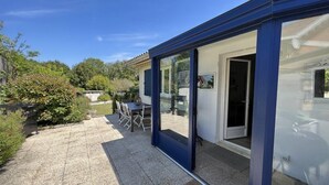 A modern house with a glass door leading to a patio area.
