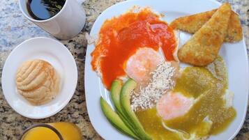 A breakfast plate with eggs, avocado, salsa, and a muffin.
