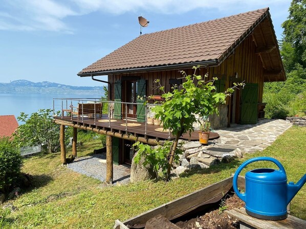 Een houten hut met een balkon dat uitkijkt over een wateroppervlak.