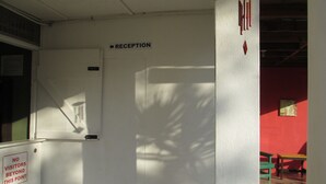 Zona de recepción con un cartel que indica 'RECEPTION' y un cartel que dice 'NO VISITORS BEYOND THIS POINT'.