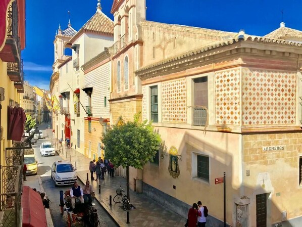 A narrow street lined with buildings, including a building with a sign that reads "ARCHEROS." - Lovely Duplex at Santa Cruz 10 people Parking Optional (Sevilla)