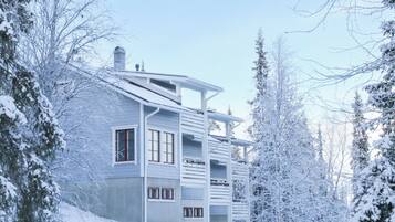 A multi-story building with a modern architectural style, surrounded by snow-covered trees.