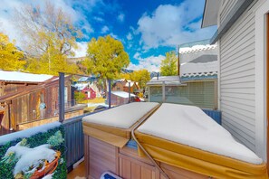 Relax in a serene outdoor seating area surrounded by a deck and a potted plant, with breathtaking views of the surrounding mountains.
