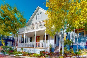 Stunning two-story home with a charming front porch and gabled roof, set amidst a tranquil neighborhood.